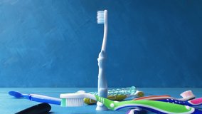 The multi-colored toothbrushes scattered on the table begin to move and gather in a pile to stand on the table, and then fall again and crumble. 4k raw funny creative loop video.