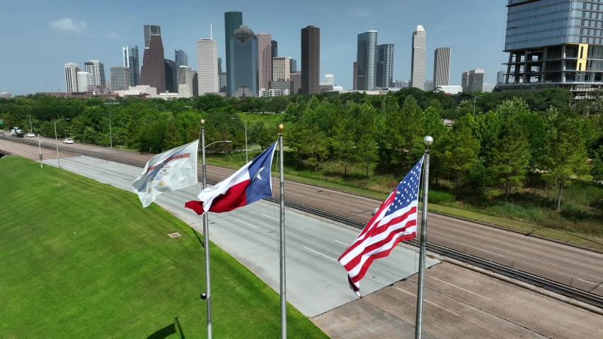 Houston Texas skyline with USA and TX state flag. Skyline aerial pullback reveal shot. Royalty-Free Stock Footage #1092518867