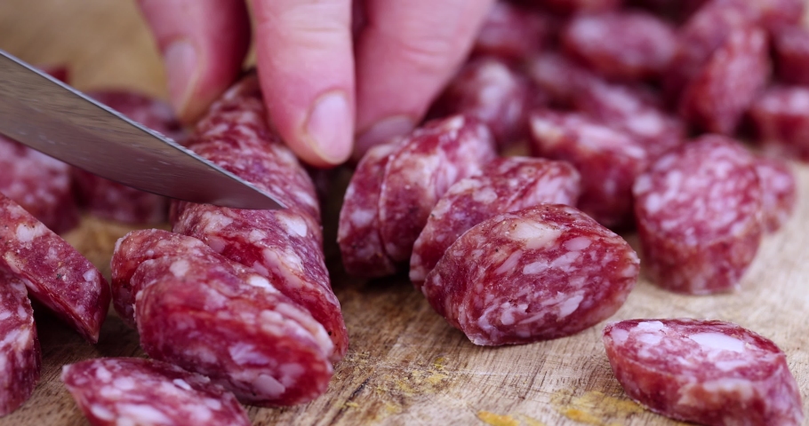 Cut into pieces thin sausage with lard on a wooden dish, sliced pork sausage and other ingredients on the table | Shutterstock HD Video #1092533263