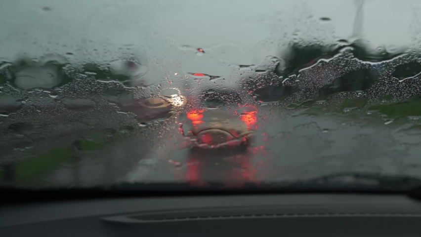 Heavy raining traffic view from inside a car. Car driving in the rain in traffic jam Royalty-Free Stock Footage #1092533303