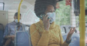 Animation of data processing over african american woman with face mask using smartphone. Global pandemic and digital interface concept digitally generated video.