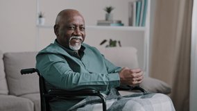 Old 60s African senior mature man alone older grandfather in wheelchair indoor at home looking window thinking pondering pensive contemplate look at camera smiling posing at apartment health insurance - Powered by Shutterstock - Get 15% off with code: PIKWIZARD15