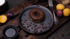 Donut with chocolate and coffee. Close-up 4k video shooting, dark background