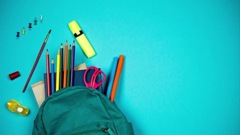 Colorful school supplies moving from school bag on blue background. Back to school concept. Stop motion – Video có sẵn