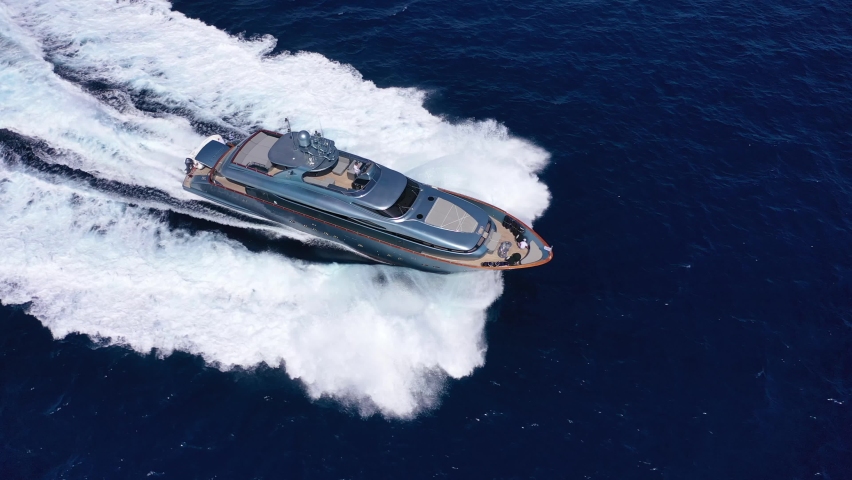 Aerial drone video of beautiful modern super yacht with wooden deck cruising in high speed in Aegean deep blue sea Royalty-Free Stock Footage #1092541313