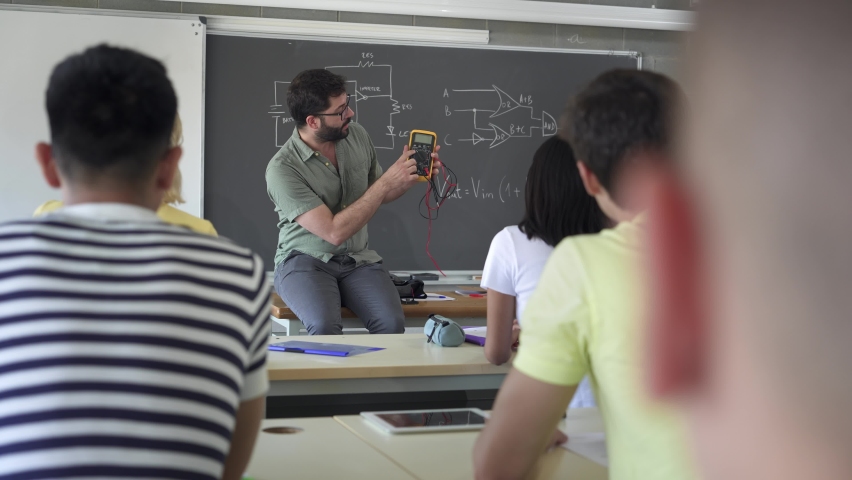 High School Teacher explaining electrical voltage tester device To Pupils learning In Technology Electronics course | Shutterstock HD Video #1092541905