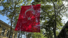 Giant Turkish flag waving over green trees wonderful panoramic view 4K video shoot abstract pastel background image buying now.
