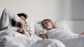 Smiling couple waking up and stretching in the morning on bed - Powered by Shutterstock - Get 15% off with code: PIKWIZARD15