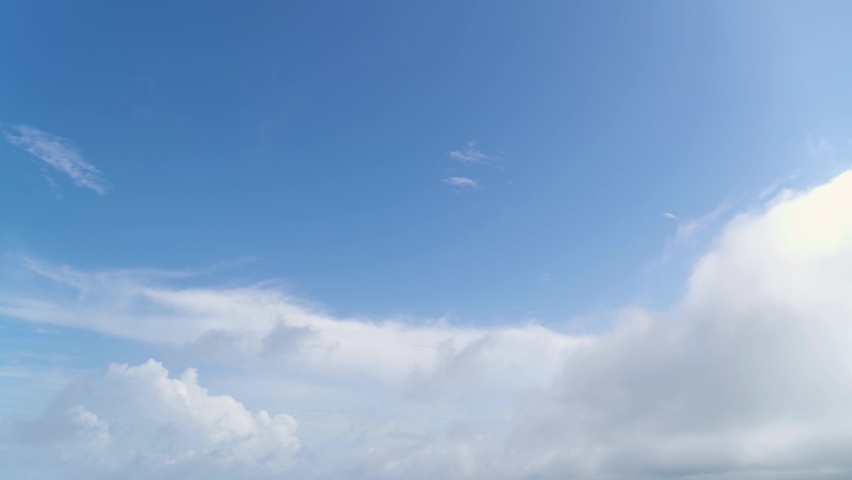 White clouds in the blue sky float slowly. atmospheric front. Sunny weather. Natural phenomenon. Royalty-Free Stock Footage #1092568101
