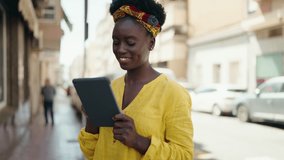 Young african american woman smiling confident using touchpad at street