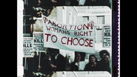 1978 Yorkshire, UK. Pro Choice demonstrators holding Abortion on Demand protest signs, marching in the streets. Pro Life protest march with school age children declaring Abortion Kills. 4K Overscan Video Stok Editorial