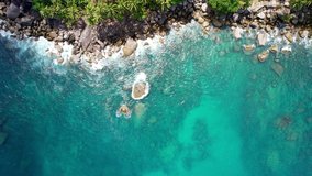 Aerial view Drone camera top down of seashore rocks in ocean, Amazing sea waves crashing on rocks seascape Aerial view drone 4k High quality of ocean with stone rock cliff