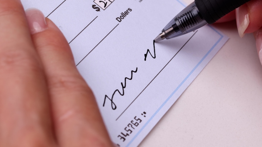 Close-up shot of a check being writen.