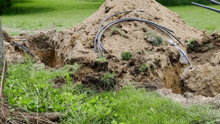 An excavator digs a trench. Close up view