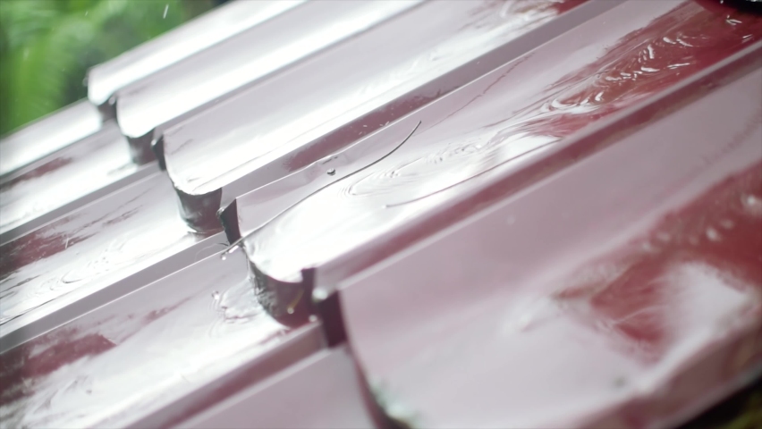 Heavy rain coming off a house roof during autumn heavy rain.