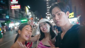 Selfie shot of Group of young happy multi race friends having fun to make selfie or technology video inside crowded China Town Night Market. Summer Holiday Vacation. Travel Experience and Memories
