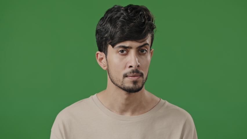 Arabic young man positively waving head, nodding approvingly. hispanic latin confident guy stands on green background showing agreement reaction answering yes support approval gesture agree accepting sign Royalty-Free Stock Footage #1092607245