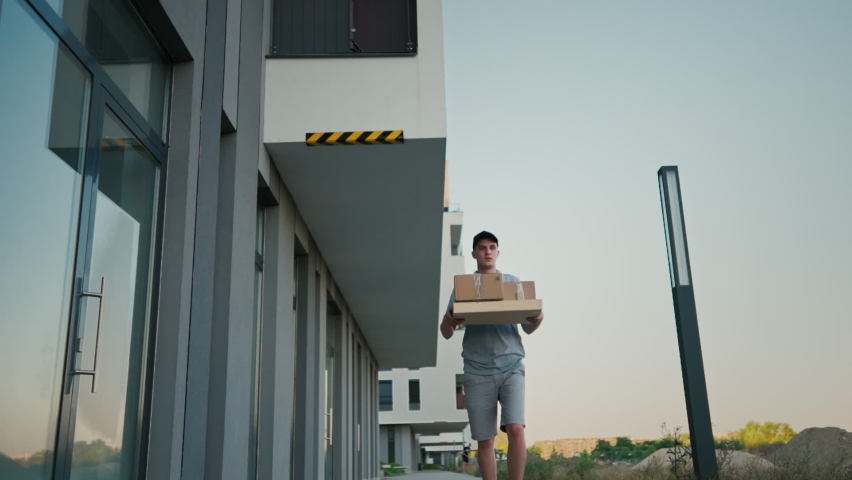 Food delivery man in uniform, slipped, lost his balance, and hurled box of food from restaurant | Shutterstock HD Video #1092607661