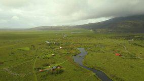establishing aerial drone footage of the country side of Iceland during the cloudy summer months. adventurer travel along the road taking in all the beauty of the natural landscape