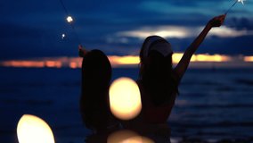Happy Young Asian woman dancing and playing sparklers firework together at tropical island beach in summer night. Attractive girl enjoy and fun outdoor lifestyle travel ocean on holiday vacation. - Powered by Shutterstock - Get 15% off with code: PIKWIZARD15