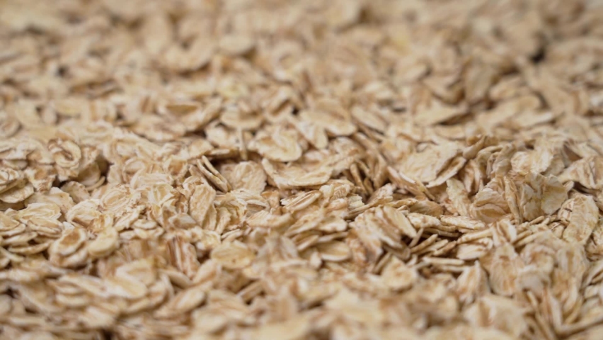 Falling rolled oat grains in raw oatmeal. Organic diet cereal healthy food. Macro. Rotation. Slow motion Royalty-Free Stock Footage #1092625079