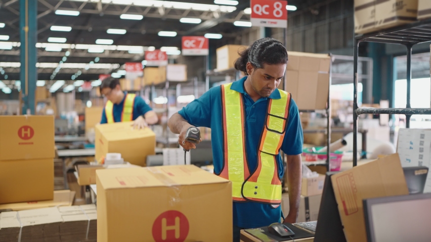 Warehouse worker using a QR code reader, scanning parcels into the system while working inside a large distribution center, worker checking goods packages and making inventory of goods. Royalty-Free Stock Footage #1092625157