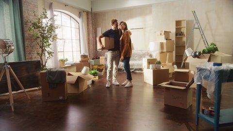 Family New Home Moving in: Happy and Excited Young Couple Enter Newly Purchased Apartment. Beautiful Family Happily Holding Hands. Modern Home Ready for Decorations. Zoom Out Energetic Dynamic Shot