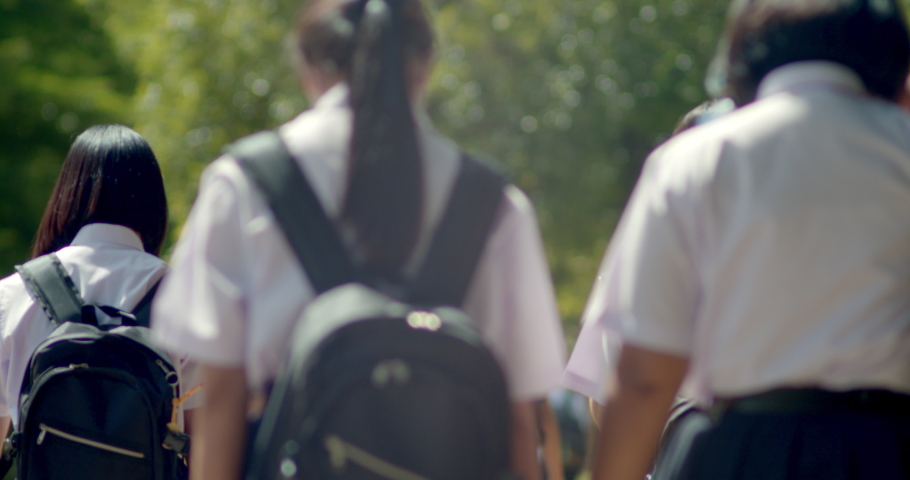 Slow motion back view of the Asian high school students in white uniform are going back to school when school starts. Royalty-Free Stock Footage #1092637397