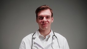 Happy doctor portrait, nurse, therapist. Medical worker smiling, posing on grey background in studio. Man wearing stethoscope, surgical uniform, looking in camera. Healthcare and medicine. - Powered by Shutterstock - Get 15% off with code: PIKWIZARD15