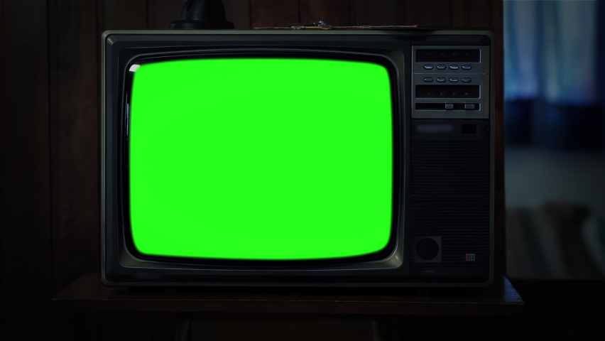 Old Television Set with Green Screen in Dark Room. Closeup. Zoom In. You can replace green screen with the footage or picture you want. You can do it with “Keying” effect in After Effects. 4K. Royalty-Free Stock Footage #1092652905