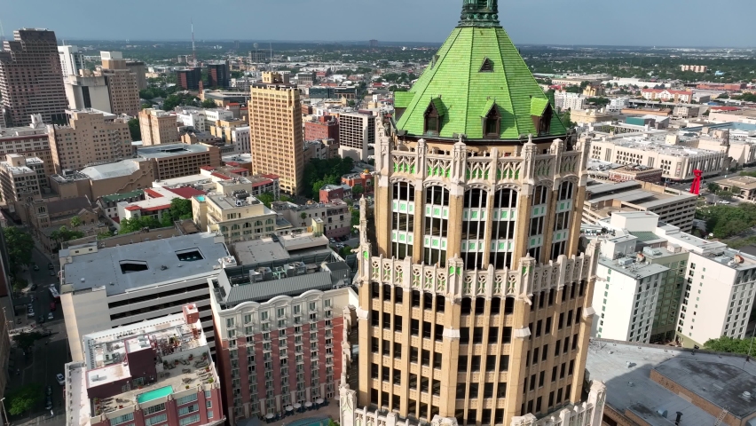 Downtown San Antonio Texas with American USA flag waving in wind. Rising aerial.