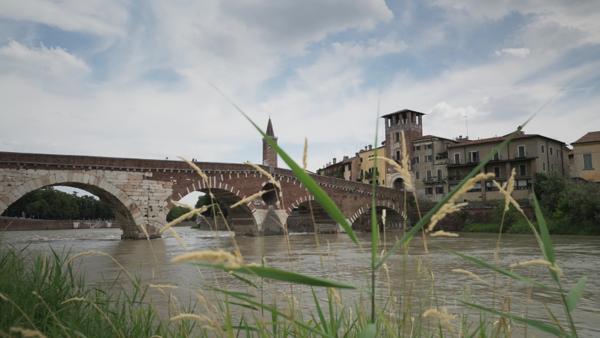 Traditional buildings on the banks of the Adige River, Ponte Pietra, Pietra stone Roman arch bridge crossing River Adige, Verona, Veneto, Italy, Europe Royalty-Free Stock Footage #1092671393