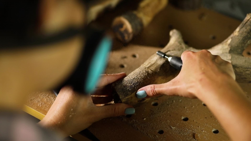 Female using power wood working tools graver, carving while crafting,