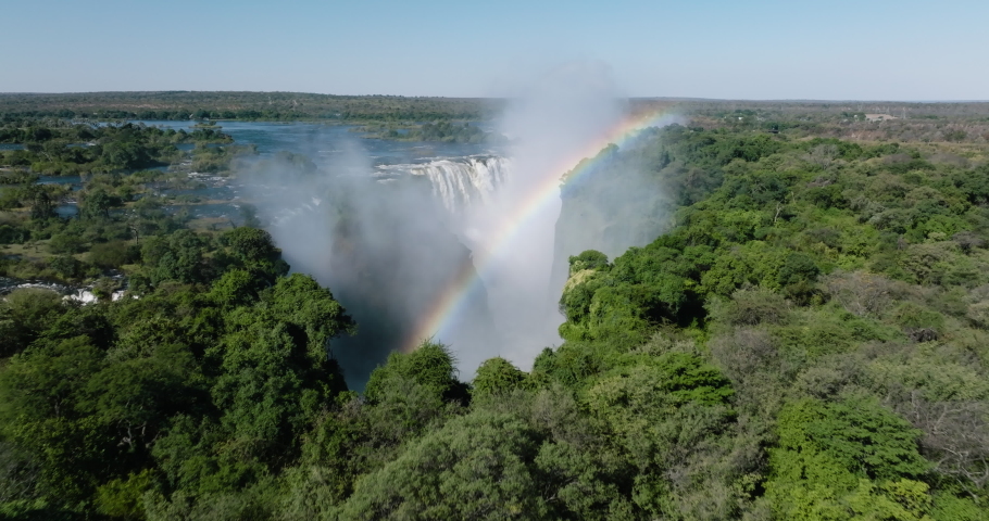 Spectacular high aerial view looking through a rainbow at the scenic Victoria falls. Unesco world heritage site Royalty-Free Stock Footage #1092674699