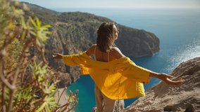 rear view happy traveler freedom filling woman with open arms smiling and enjoying mountains view, summer journey vacation in Butterfly valley,Turkey. girl stands on top of cliff over sea - Powered by Shutterstock - Get 15% off with code: PIKWIZARD15