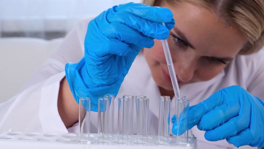 Close up research chemist takes samples for research and works in a laboratory with a micropipette and a microscope. | Shutterstock HD Video #1092682937