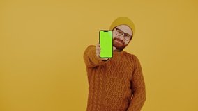 Young man showing the smartphone screen with green chroma key and showing the thumb up gesture . High quality 4k footage - Powered by Shutterstock - Get 15% off with code: PIKWIZARD15