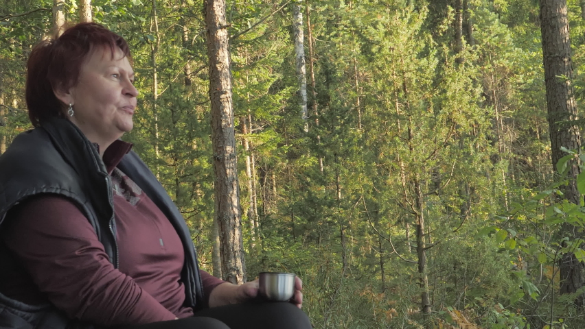 The tall trees on the back of the lady in Espoo Finland while taking her tea break in the nature reserve.geology shot.4k