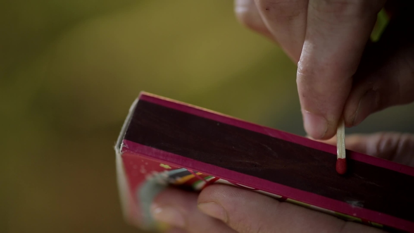 Close up of unidentified hand striking matchstick over matchbox to ignite it. | Shutterstock HD Video #1092692171