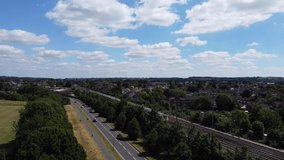 High Angle footage and Aerial View of Train Tracks passing through British town of England. Train on Tracks approaching to Railway Station of London Luton Town.