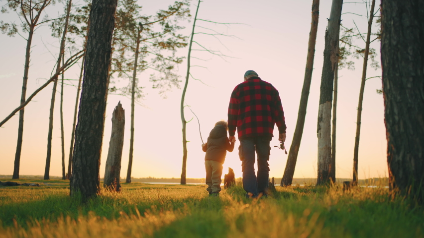 hiking and fishing in nature in summer weekend, old fisherman and his grandson are walking to river Royalty-Free Stock Footage #1092695063