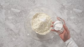 Time lapse. Mixing ingredients in a glass mixing bowl to prepare coconut banana pancakes.