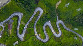 4K Aerial footage view of winding road in the highland forest