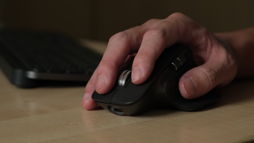 Selective focus, close up shot at men hand while using wireless mouse to surfing internet and working with his computer. Computer device and technology concept. | Shutterstock HD Video #1092711689
