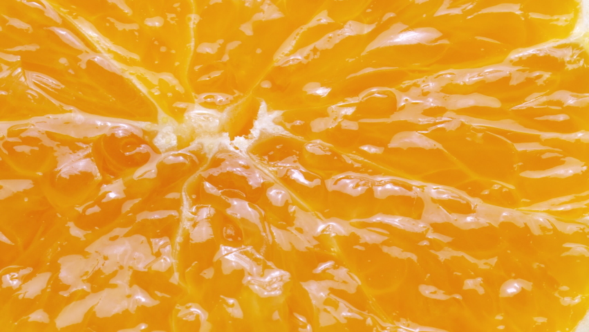 Squeezing a fresh and juicy orange. Extreme close up.