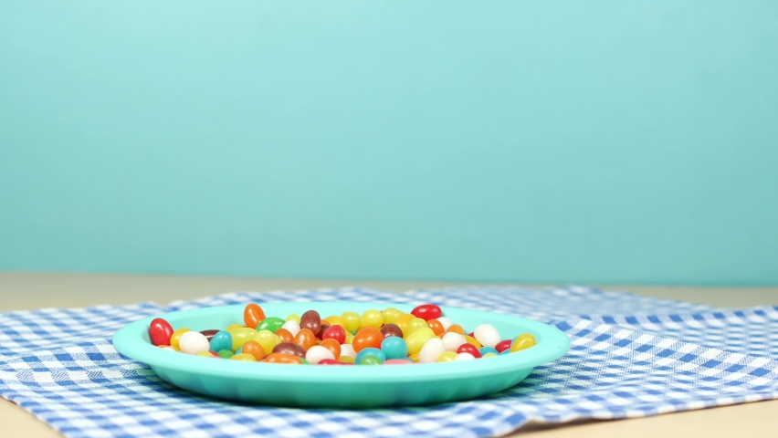  hand pick of Jelly beans dropping on a plate ,