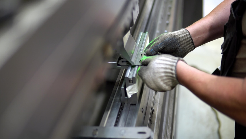 The employee hands are not bending the large parts of the metal on the bending machine, closeup. The CNC operator bending a metal product bends. The employee works at the metal factory. | Shutterstock HD Video #1092721737