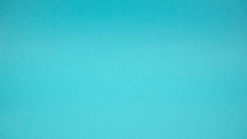 Shopping trolley with books moving on blue background. Stop motion