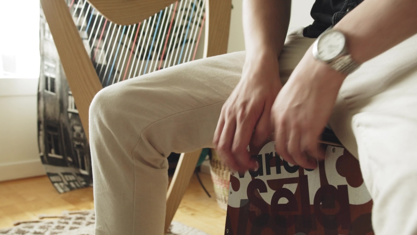 Man drumming cajon box inside, closeup