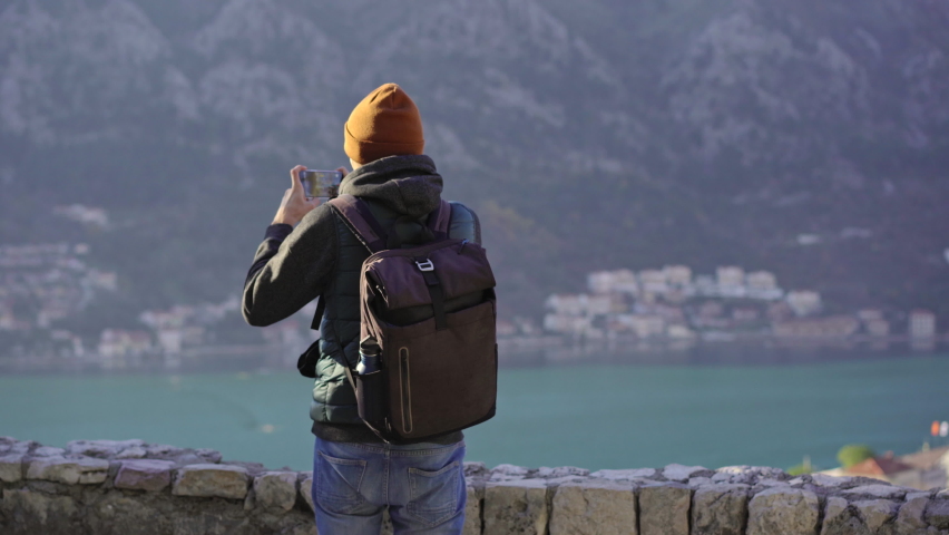 A man tourist visits the old town of Kotor in Montenegro. He is enjoying fabulous view of the city climbing up the stairs to the st.John